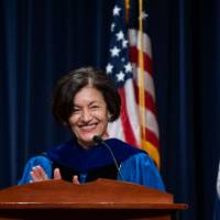 Fatma smiling and clapping at the podium
